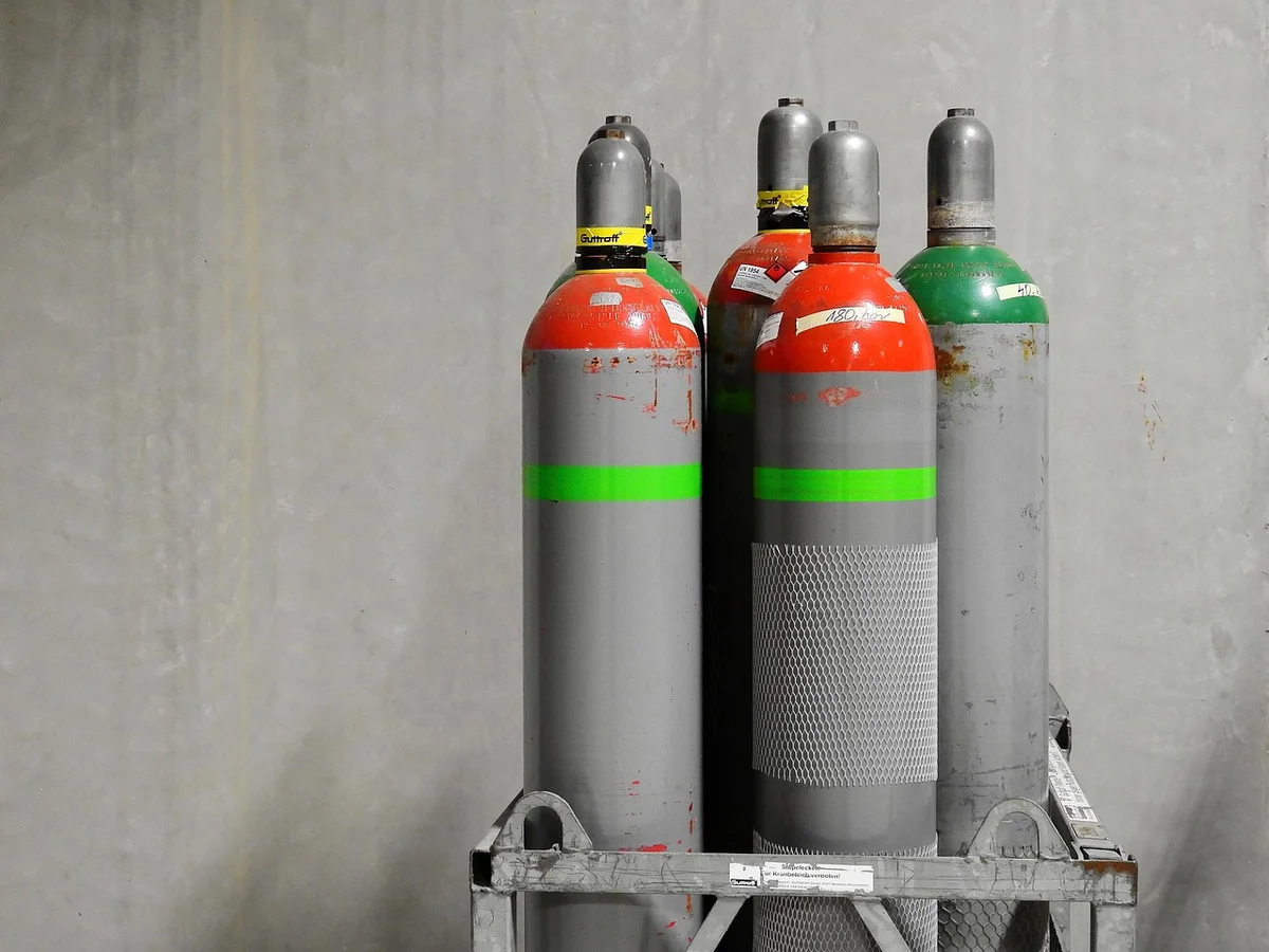 Oxygen and acetylene gas cylinders secured upright on a cart