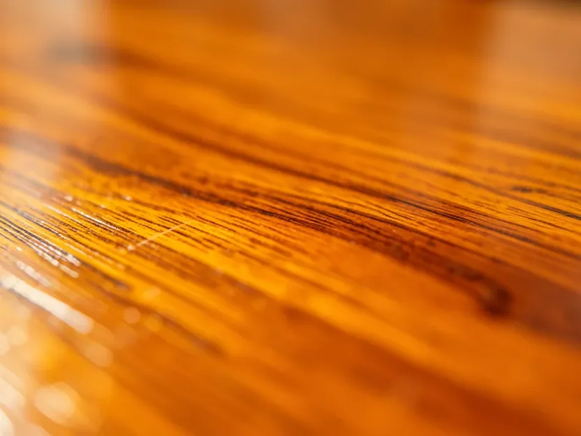 Close-up of a cured oil-based polyurethane finish showing the warm amber tone it develops over wood grain