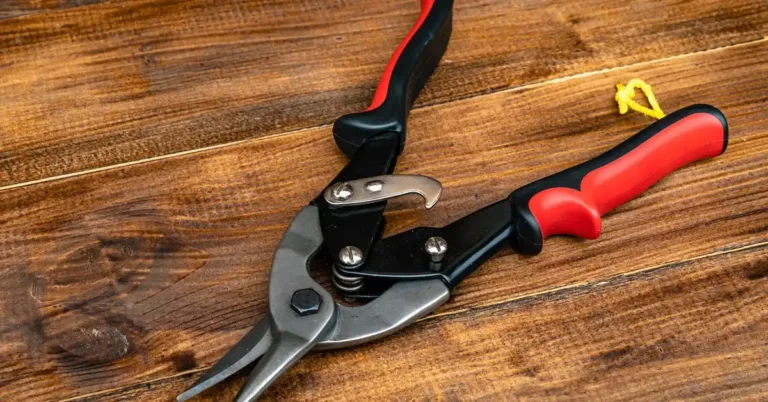 aviation-style power metal snips lying open on a workbench