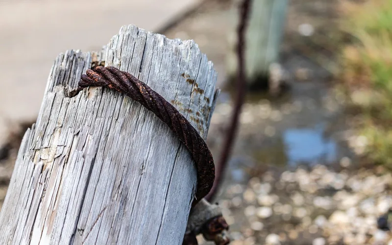 Close-up of a weathered metal fence post