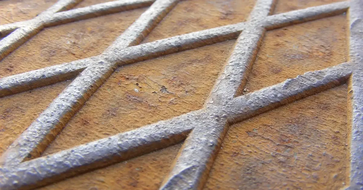 Rusted steel diamond plate showing orange surface rust