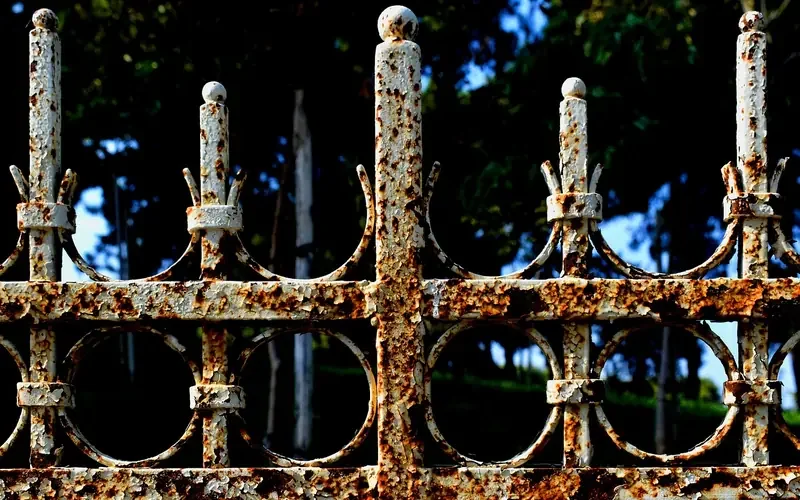 Weathered rusty iron fence showing an aged rust patina