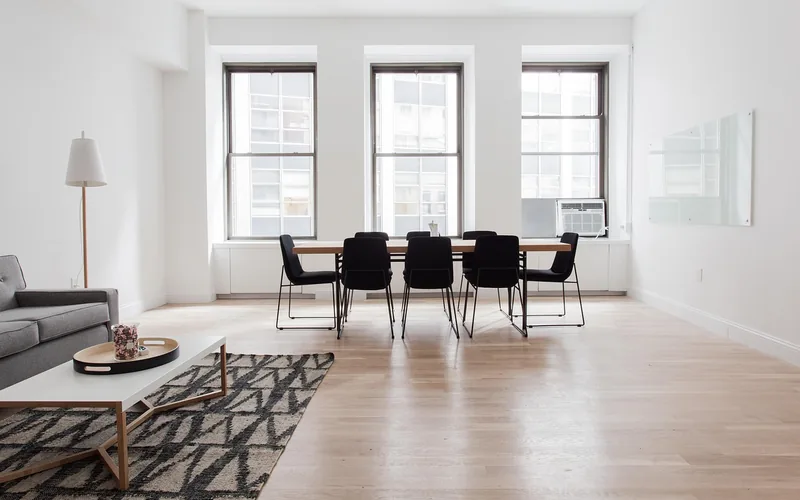 Satin-finish hardwood floor in a bright living room with soft window reflections