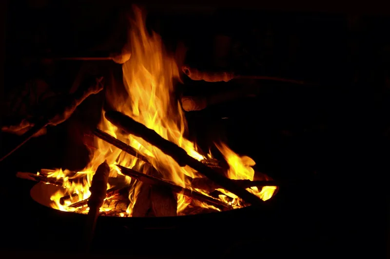 Small wood fire burning in a metal fire bowl at night Small wood fire burning in a metal fire bowl at night