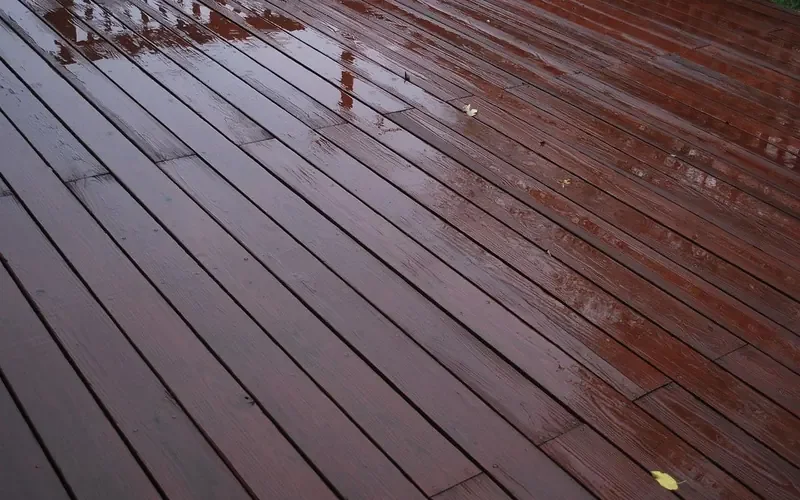 rain water sitting on the surface of coated wooden deck boards