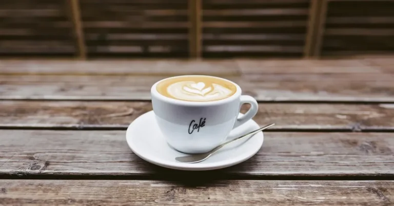 Coffee cup on a saucer resting directly on a weathered wooden table