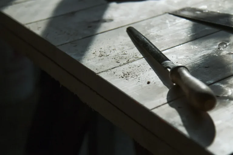 Weathered wooden workbench with a hand tool and fine wood dust