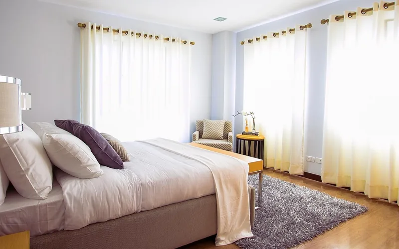 plush area rug layered over hardwood flooring in a bedroom to dampen footstep noise