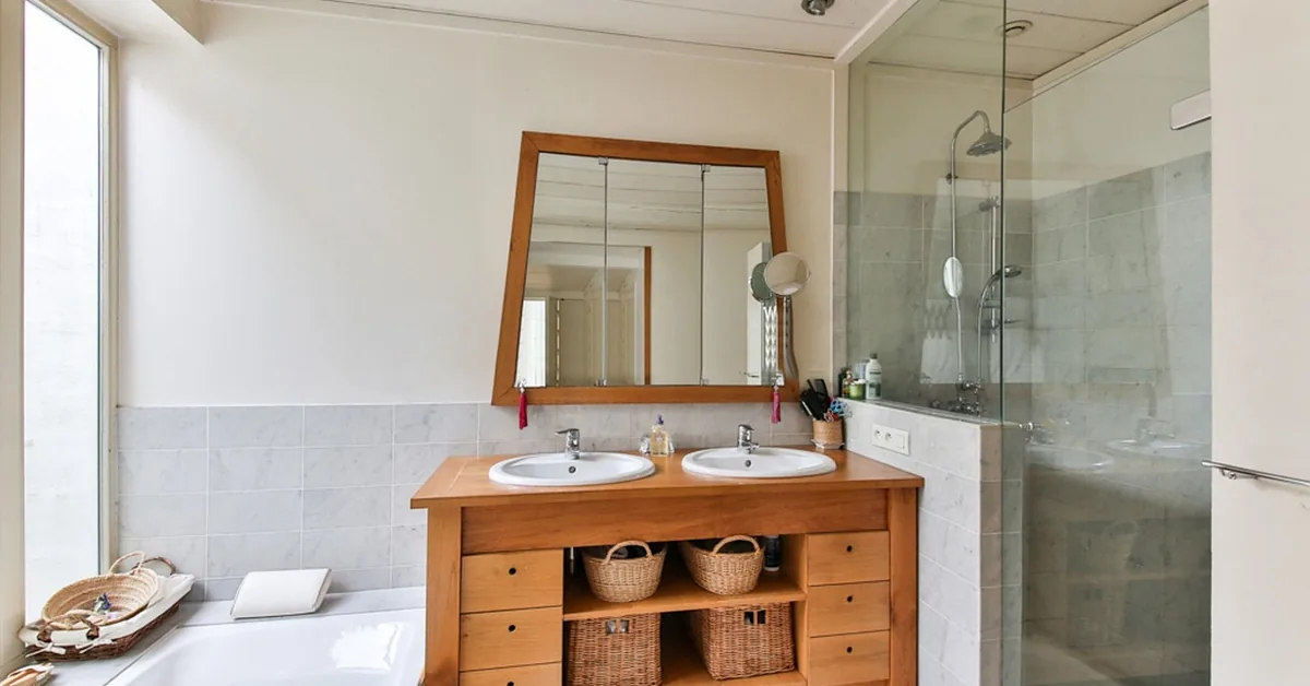 Bathroom with a wood double vanity, mirror, and glass shower
