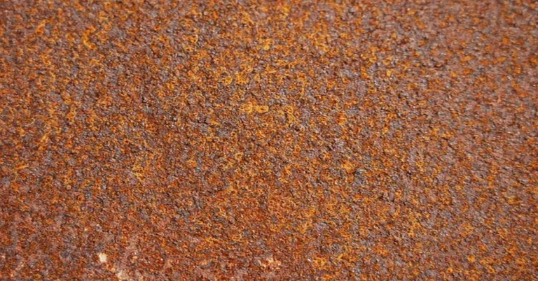 Close-up of a bare rusty metal surface before cleaning and priming