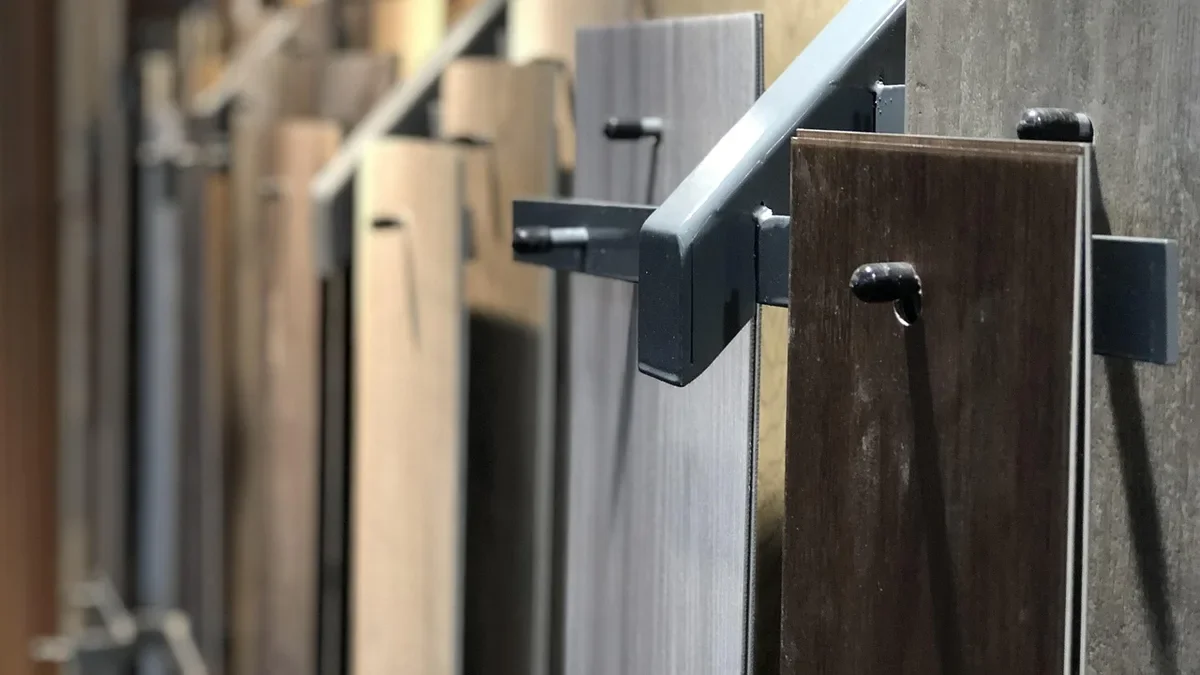 Rack of wood-look flooring plank samples in a flooring showroom