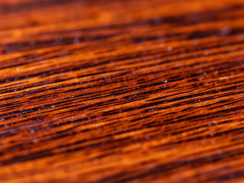 Close-up of genuine mahogany wood grain showing its reddish-brown color and fine tight grain