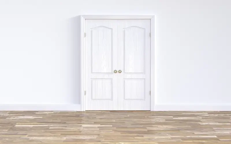 Closed white interior door in its frame, where an even gap at the top shows the door is hanging square Closed white interior door in its frame, where an even gap at the top shows the door is hanging square