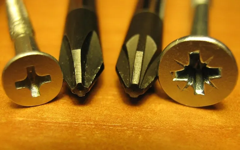 Phillips screw and Pozidriv screw heads next to their screwdriver tips