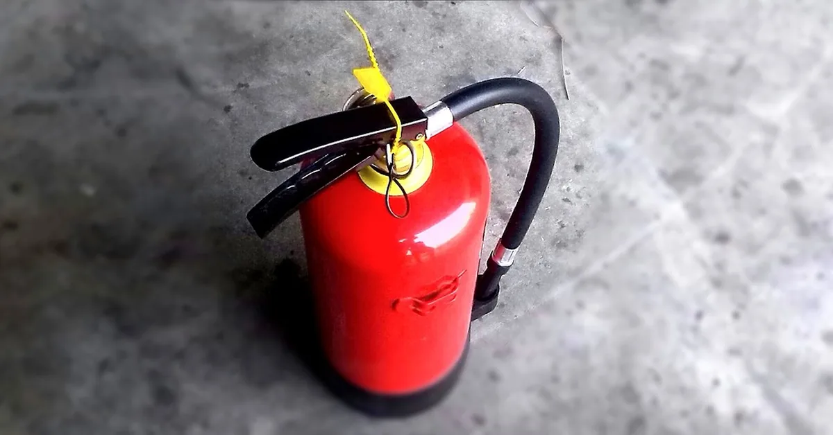 red fire extinguisher on a garage workshop floor