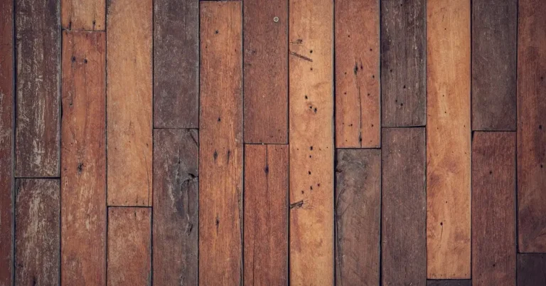 Worn original wood plank flooring in an old house showing gaps and uneven boards typical before leveling