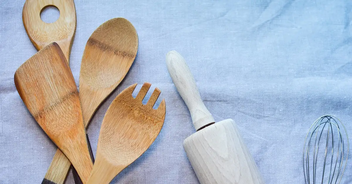 acacia wood cooking utensils spoons and rolling pin on linen