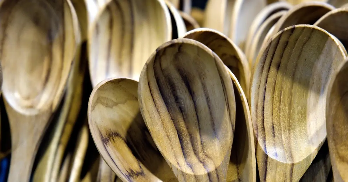 Row of wooden cooking spoons showing dark grain streaks
