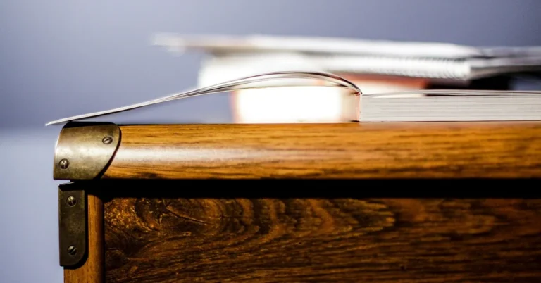 Close-up of a solid wood dresser corner with brass hardware, showing natural furniture-grade wood grain