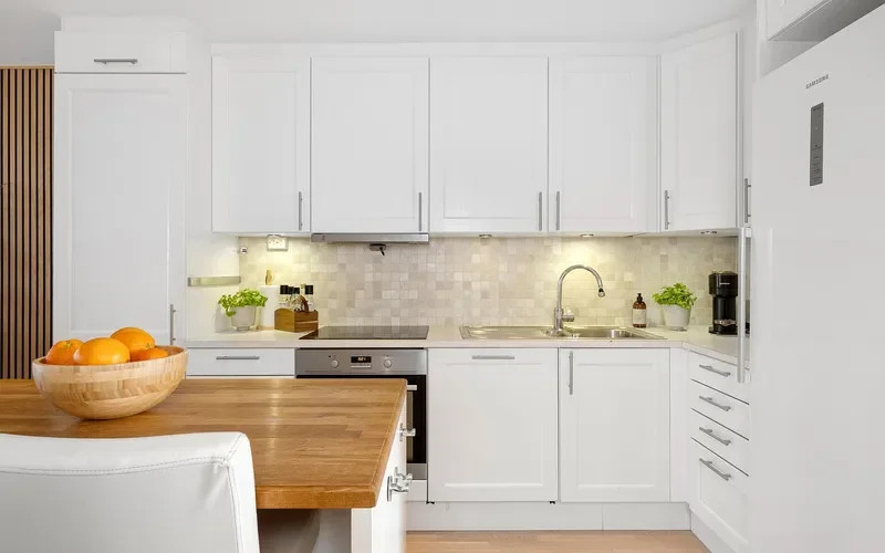 White painted shaker cabinet doors in a kitchen with a wood countertop White painted shaker cabinet doors in a kitchen with a wood countertop