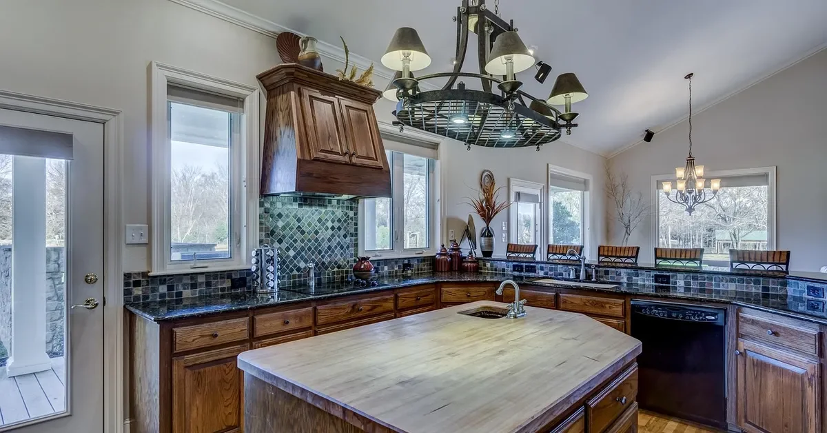 Kitchen with stained solid wood cabinet doors and a butcher block island