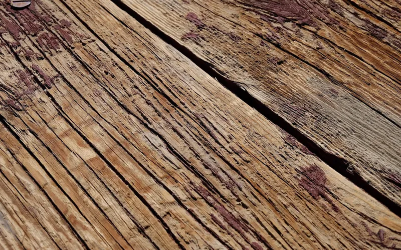 Weathered outdoor wood plank with surface checking and discoloration Weathered outdoor wood plank with surface checking and discoloration