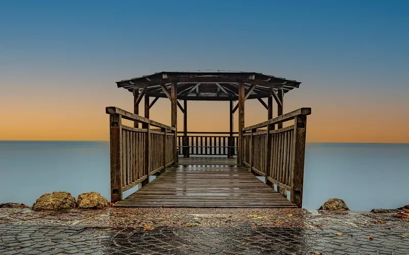 Wooden walkway and gazebo exposed to sun and water