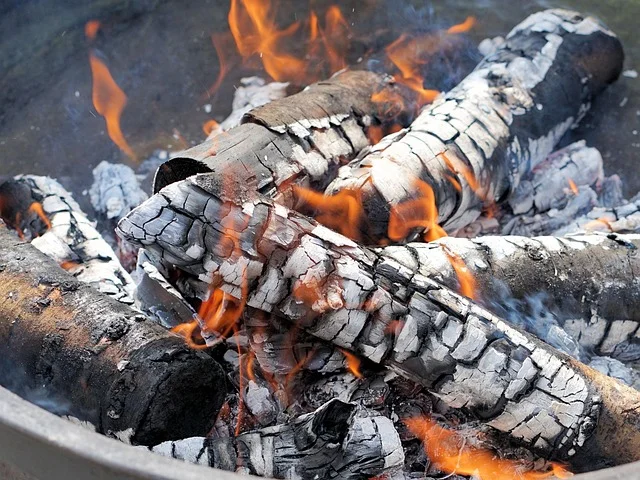 Ash firewood burning down to glowing embers and white ash