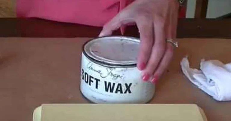 hand opening a tin of clear furniture wax next to a wax brush and cloth for fixing blotchy chalk paint