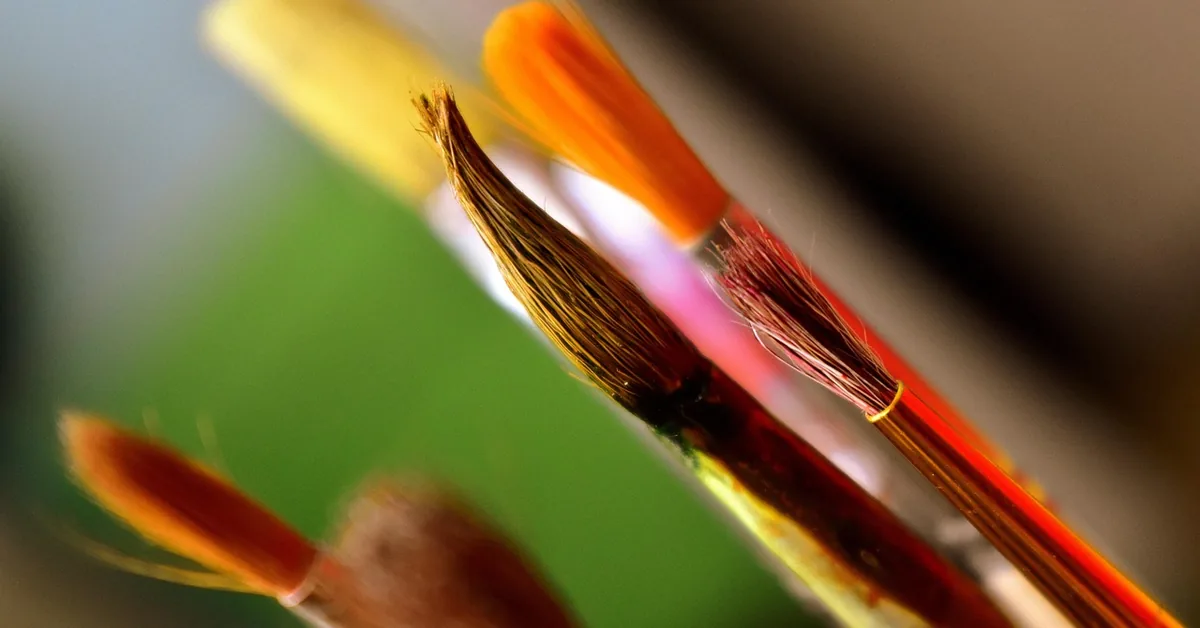 paintbrush bristles caked with dried acrylic paint at the ferrule, close up