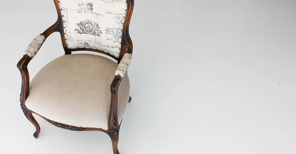 Antique wood armchair with a hand-carved frame showing a built-up paste wax finish