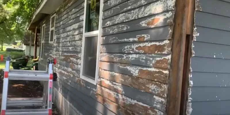 Peeling paint on old cedar siding showing why priming before repainting matters