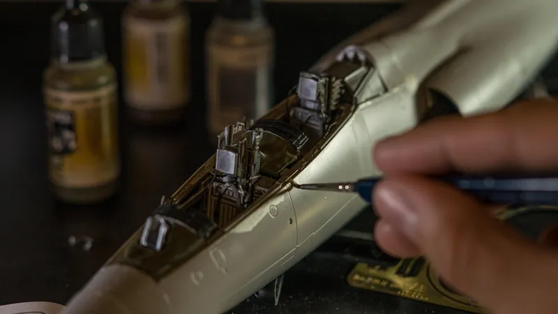 Hand holding a fine tool for detail work on a scale model Hand holding a fine tool for detail work on a scale model