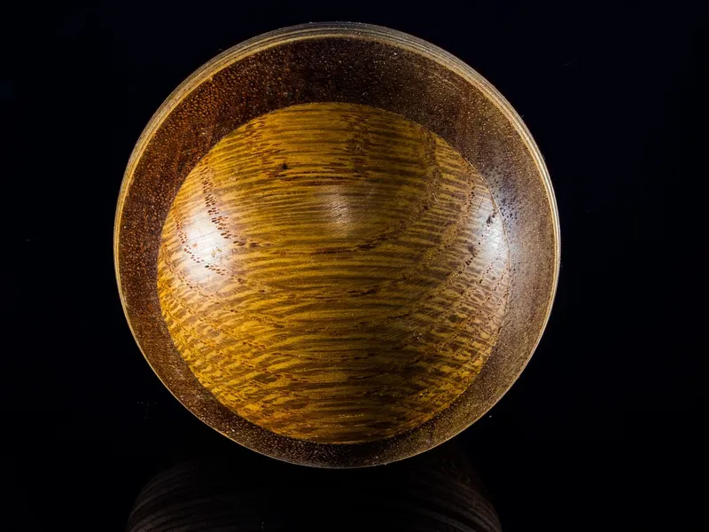 Turned wood bowl with a mirror-like rubbed-out gloss finish reflecting light