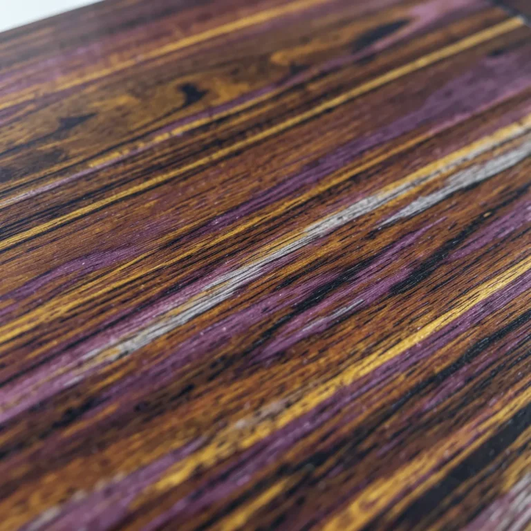 close-up of shedua wood plank showing dark brown and purple streaked grain