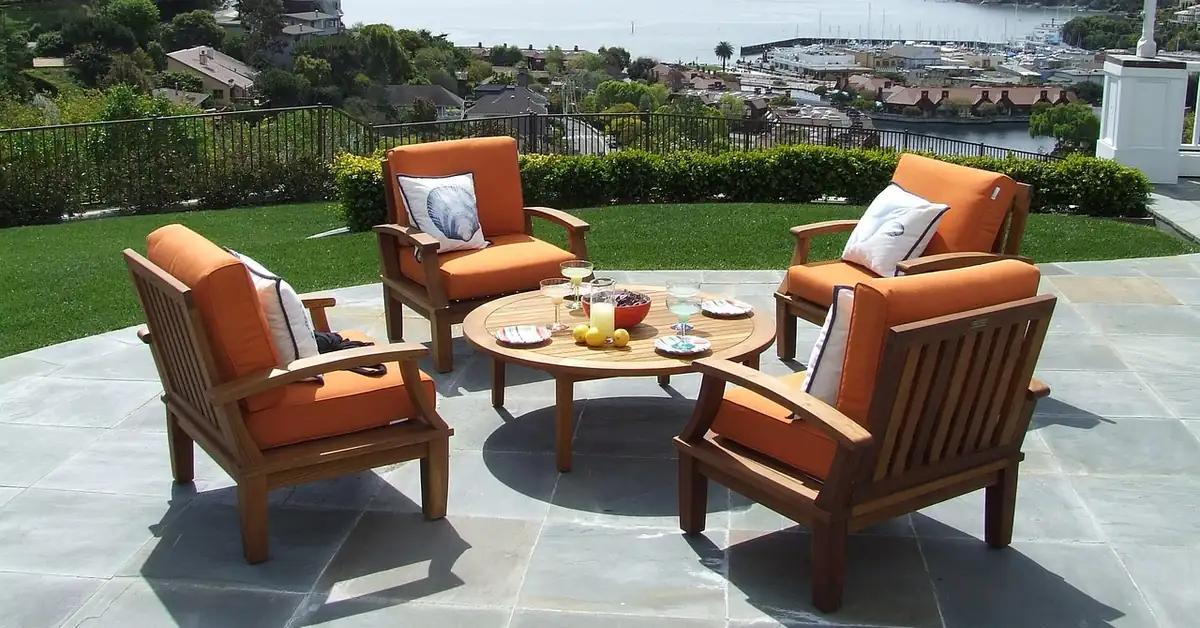 Teak armchairs and round table on a stone patio