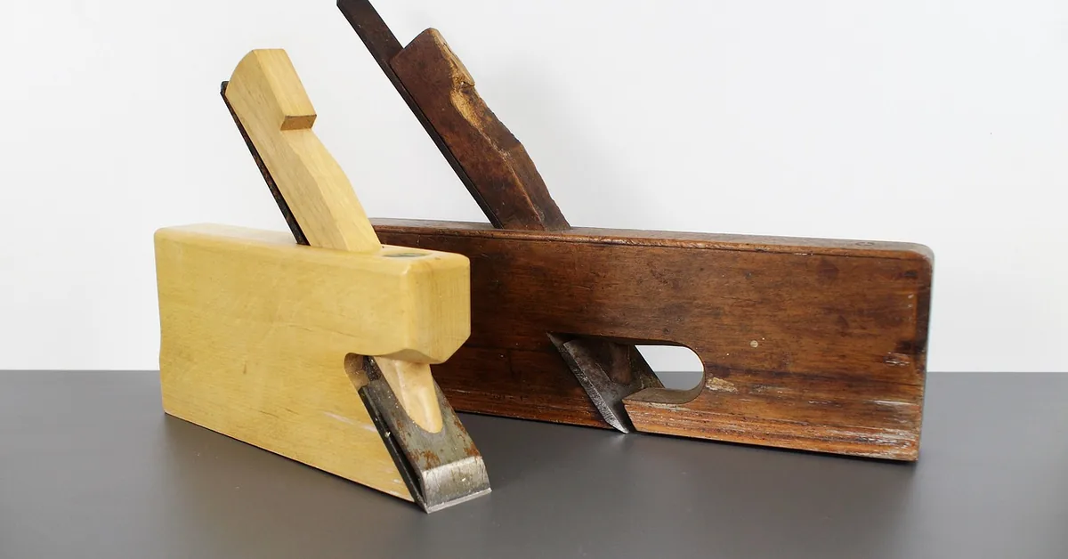 Carpenter using a hand plane to smooth a wood surface before applying finish Carpenter using a hand plane to smooth a wood surface before applying finish