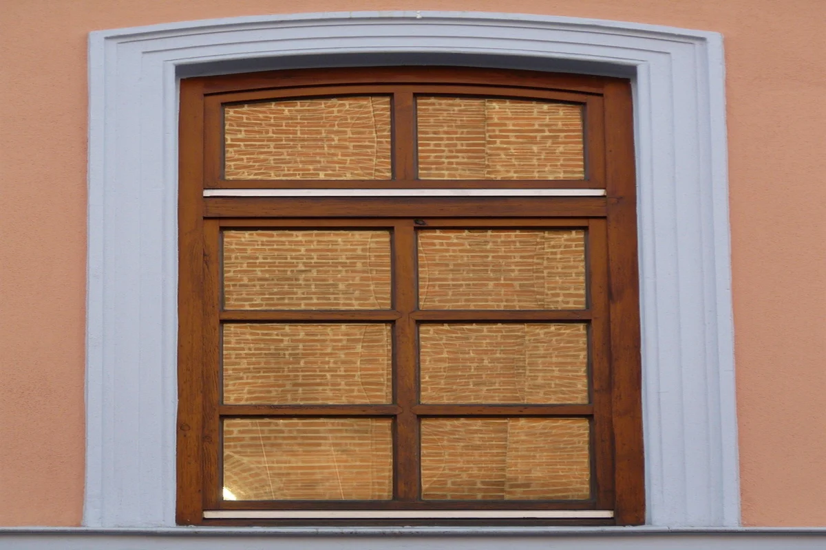 Wood-framed window with painted shutters on a home exterior