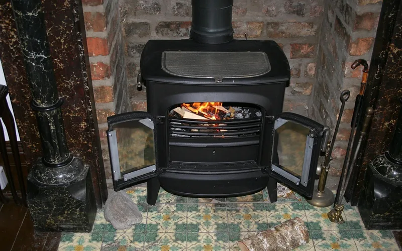 wood burning stove glowing with seasoned logs inside