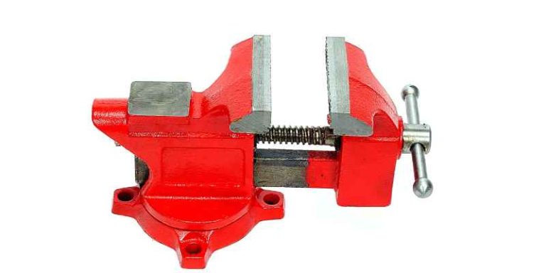 Red quick-release bench vise mounted on a wooden workbench
