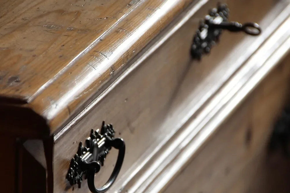 Close-up of an antique wooden chest of drawers with an aged finish
