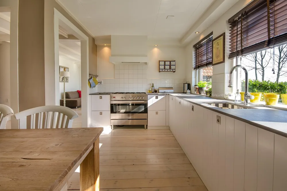Bright kitchen with a light plank floor, a room where laminate vs LVP water resistance matters