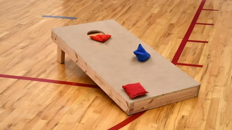 Cornhole board with bean bags on a gym floor