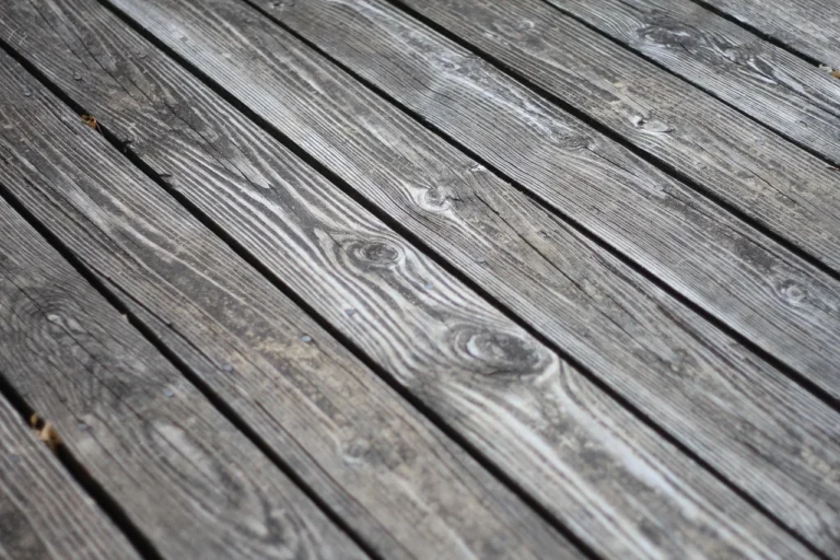 Weathered gray unsealed exterior wood decking showing UV and moisture patina