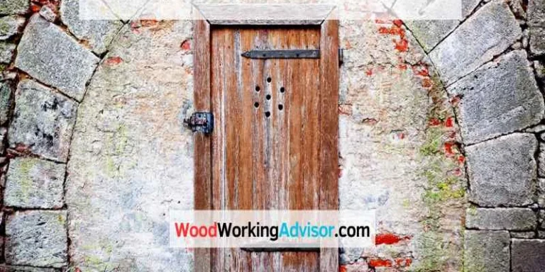 Old wooden door with damage in a stone archway