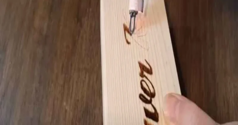 Pyrography pen burning a design into light basswood for a beginner wood burning project