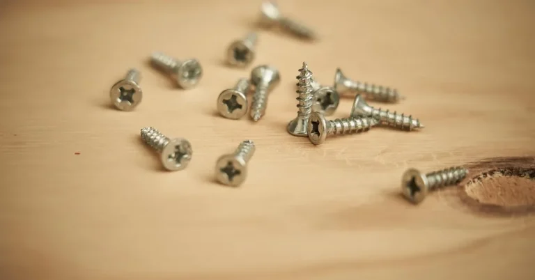 Loose wood screws scattered across a pine board