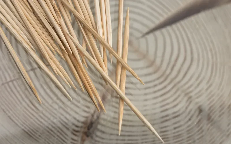 Wooden toothpicks scattered over a cut wood board, the plug material for stripped screw hole repairs Wooden toothpicks scattered over a cut wood board, the plug material for stripped screw hole repairs