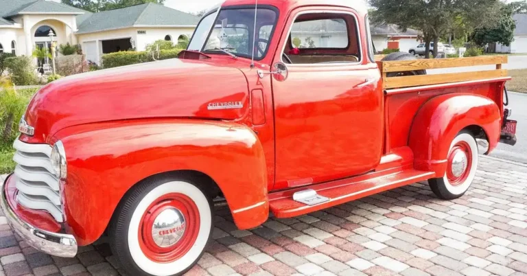 Vintage red pickup truck with a wooden bed floor and wooden stake side rails