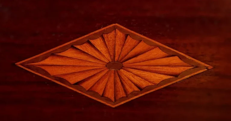 Fan-shaped wood veneer inlay on a mahogany furniture panel